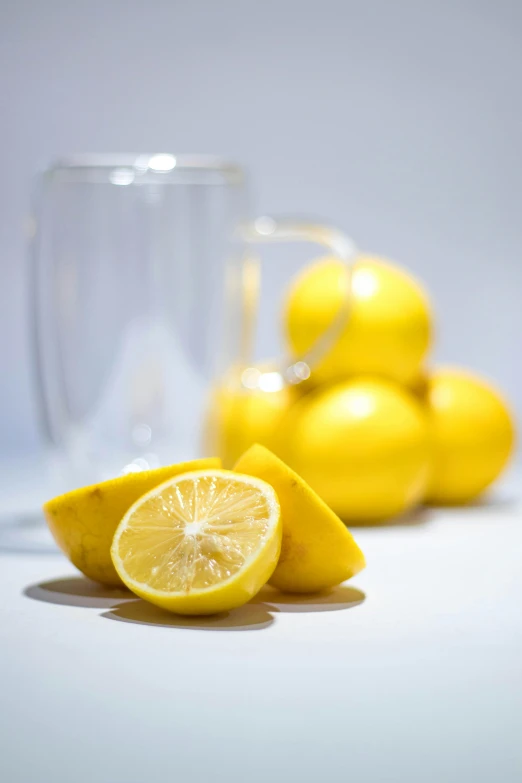 a glass vase with a lemon and one half cut up