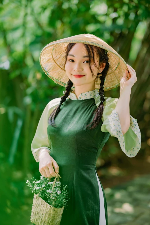 young woman with ids and green dress holding green plants