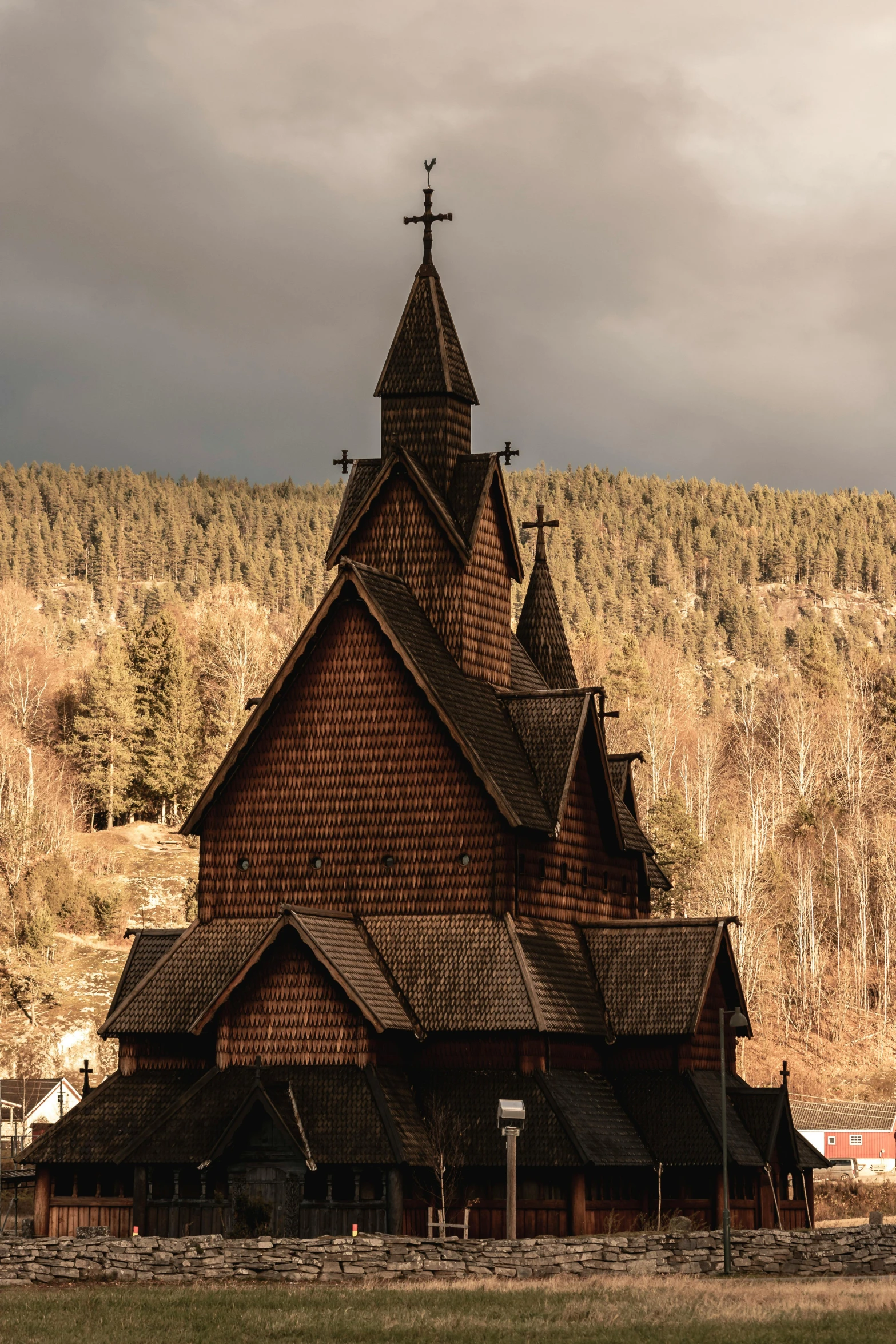 the tall church is next to a tree filled hillside