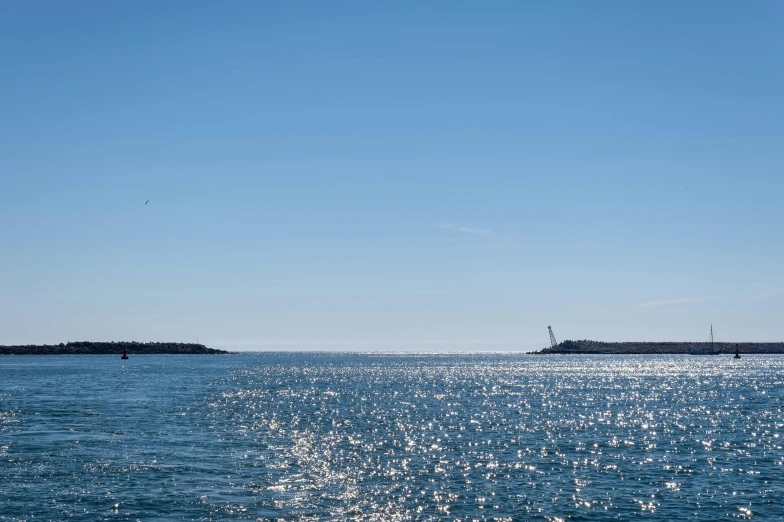 the ocean with blue skies and several large ships in the distance