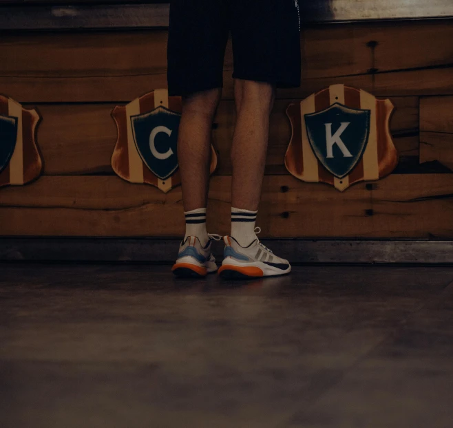 person standing beside wooden walls, holding on to their socks