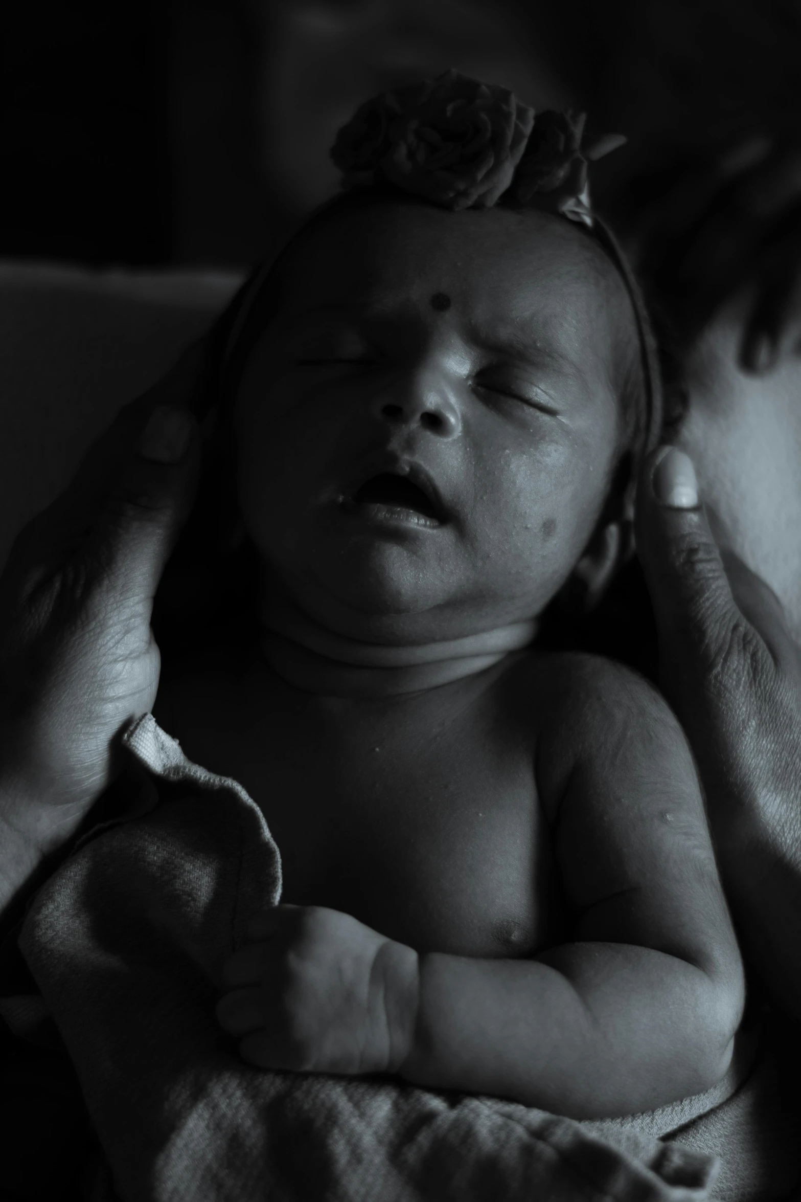 a woman holding a newborn child and looking at it