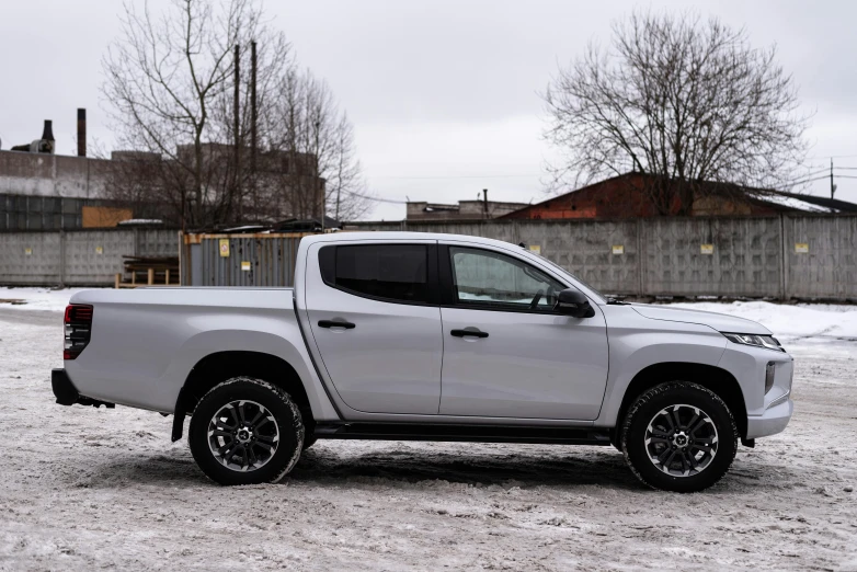 a silver pick - up truck sitting in the snow