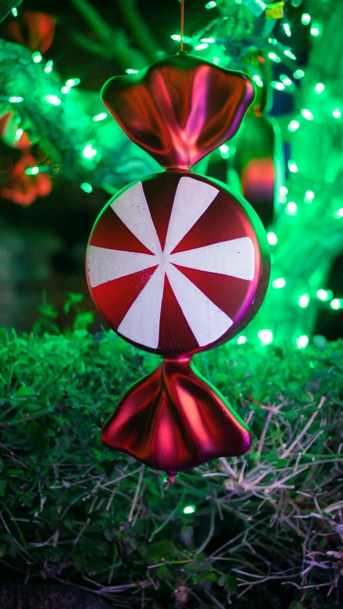 a bright green christmas tree decorated with a candy cane