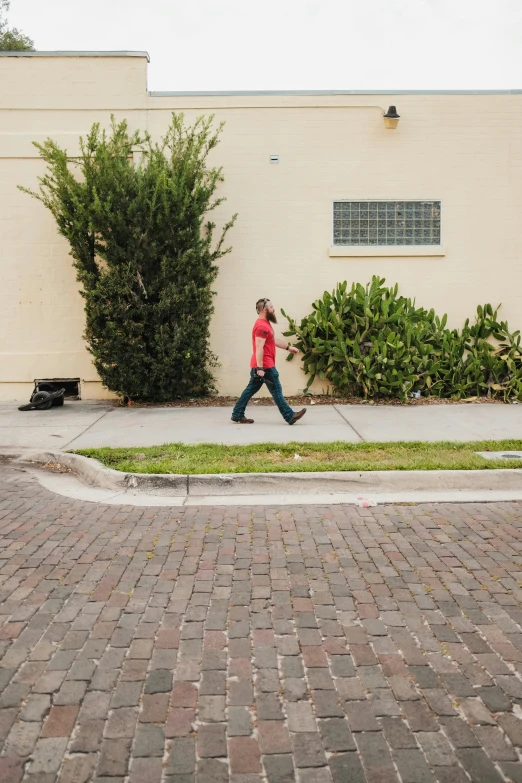 a person is walking down the sidewalk while holding a cellphone