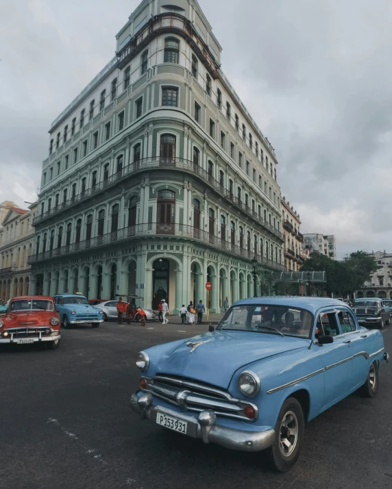 old cars and a bus in front of an ornate building