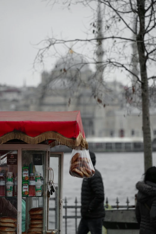 a pastry shop with people on the water behind it