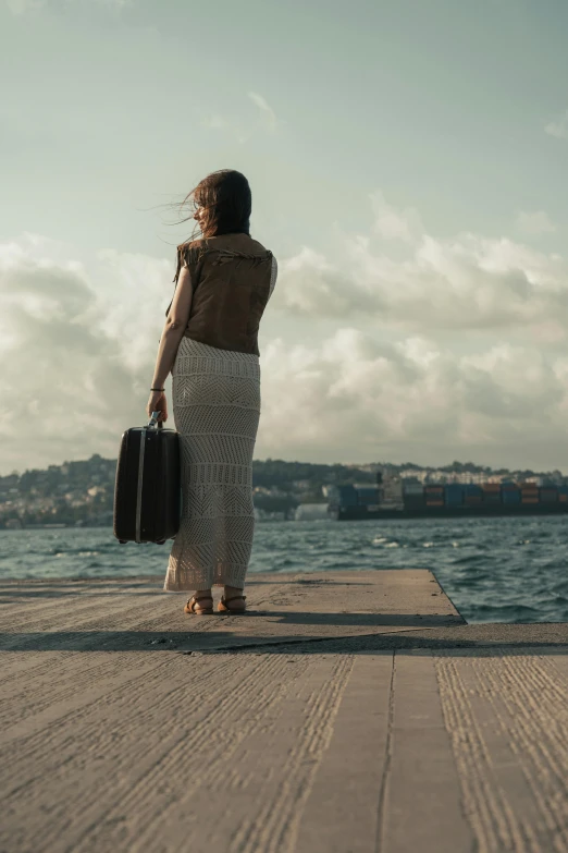 a woman carrying her suitcase while standing on the boardwalk