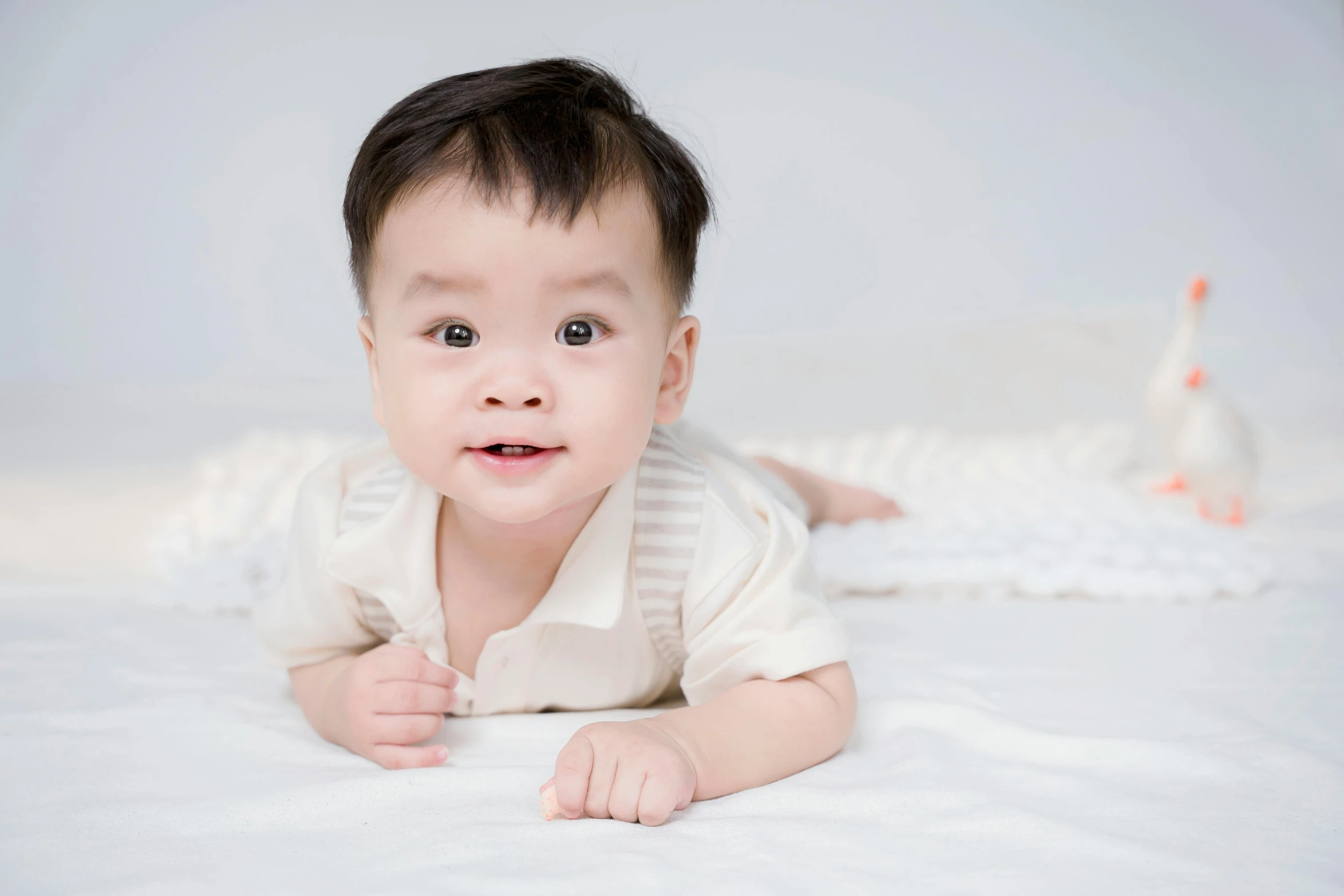 a baby laying on its stomach on a white bed