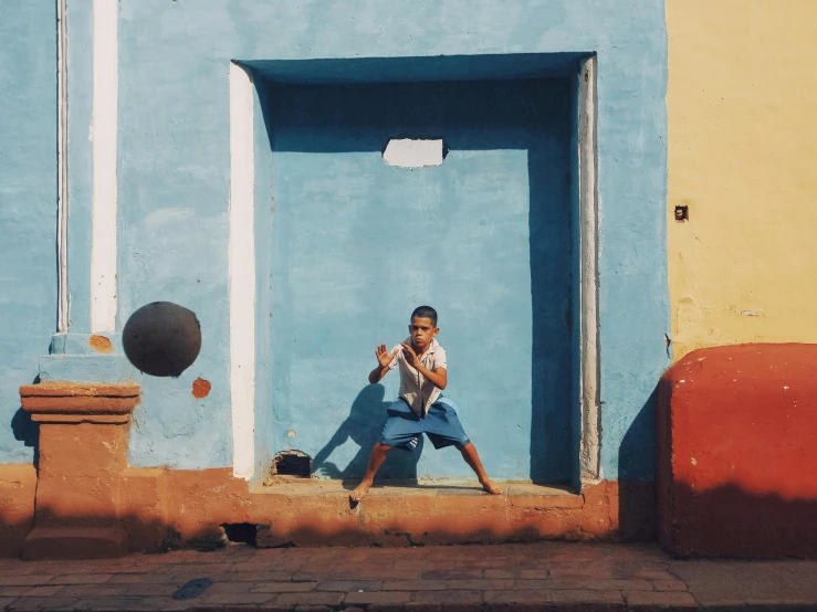 a man squatted in front of a doorway with his legs crossed