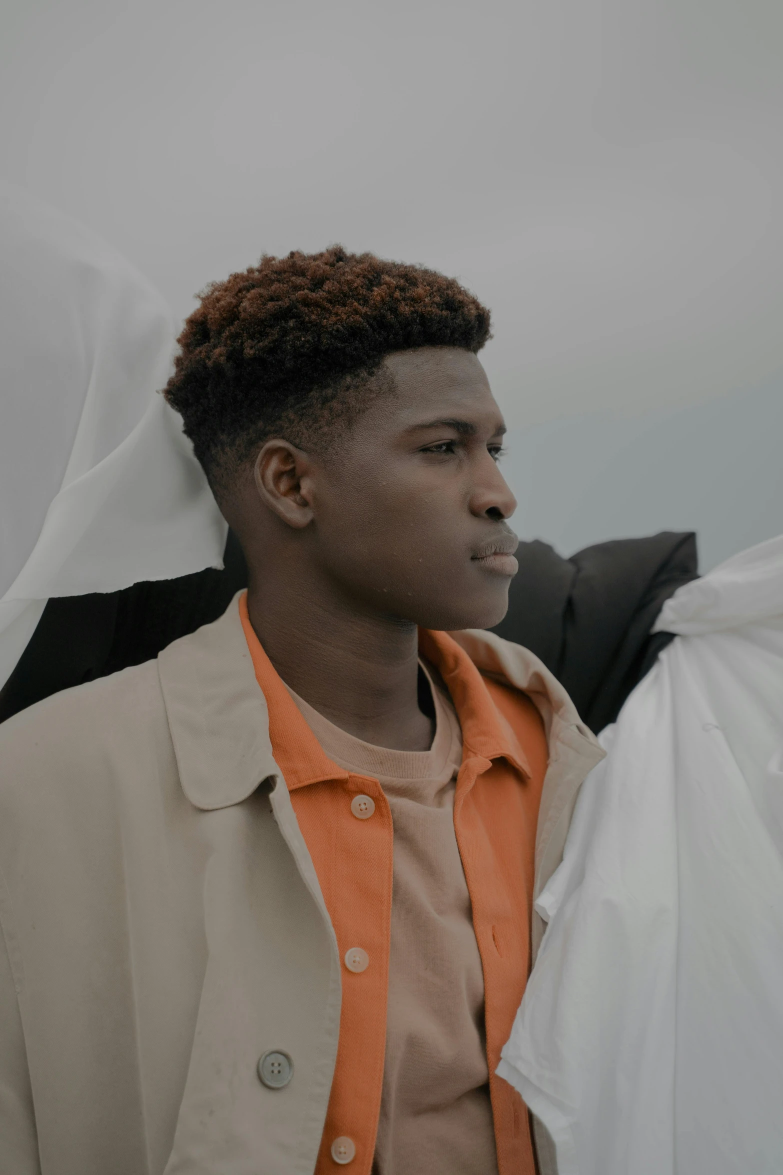 a man standing with an orange shirt around his neck