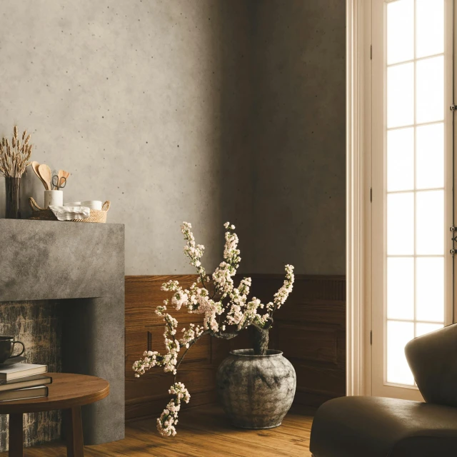 the white flowers in the grey vase is displayed near the fireplace