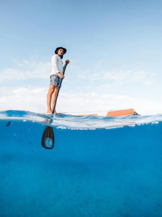 a woman paddle surfing on the surface of the ocean