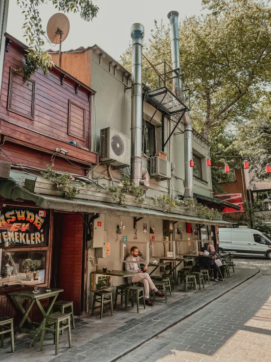 there are many people sitting outside the cafe