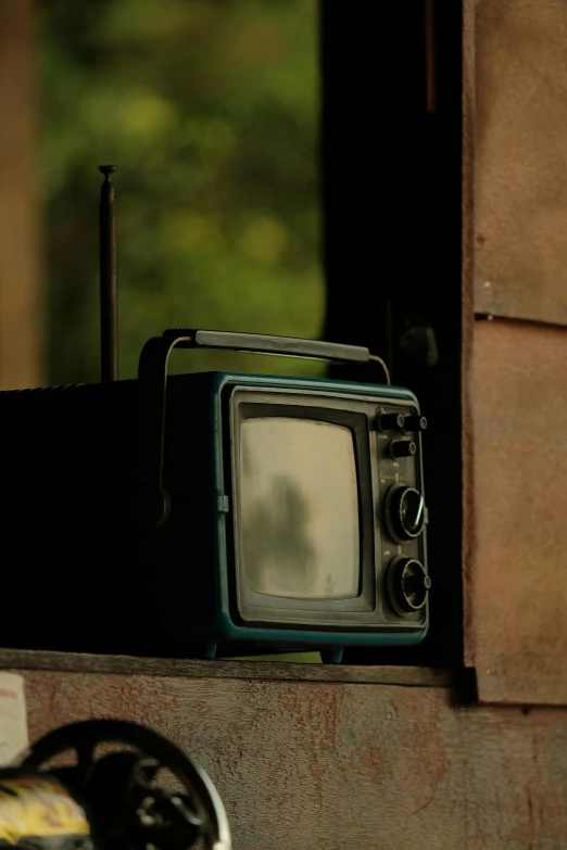 a small old style television is in an open window