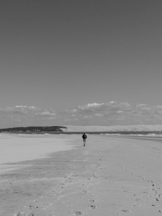 the person is running along the sandy beach