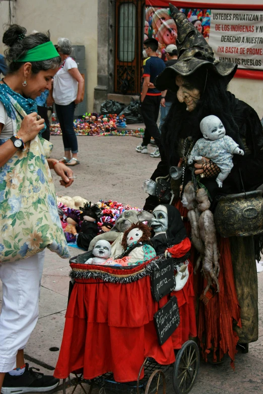 two women looking at some stuffed toys on a sidewalk