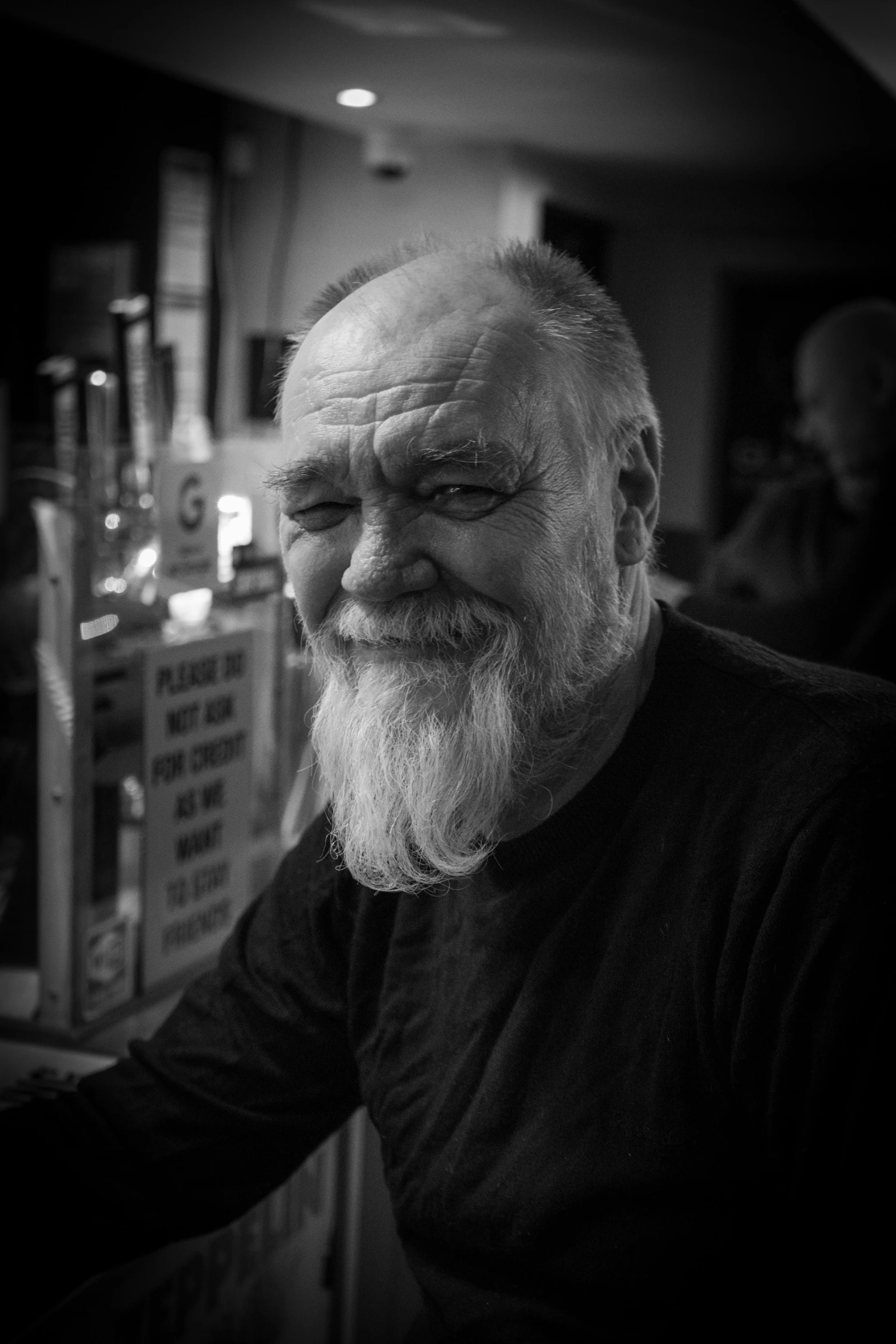 an old man with a white beard in front of some liquor