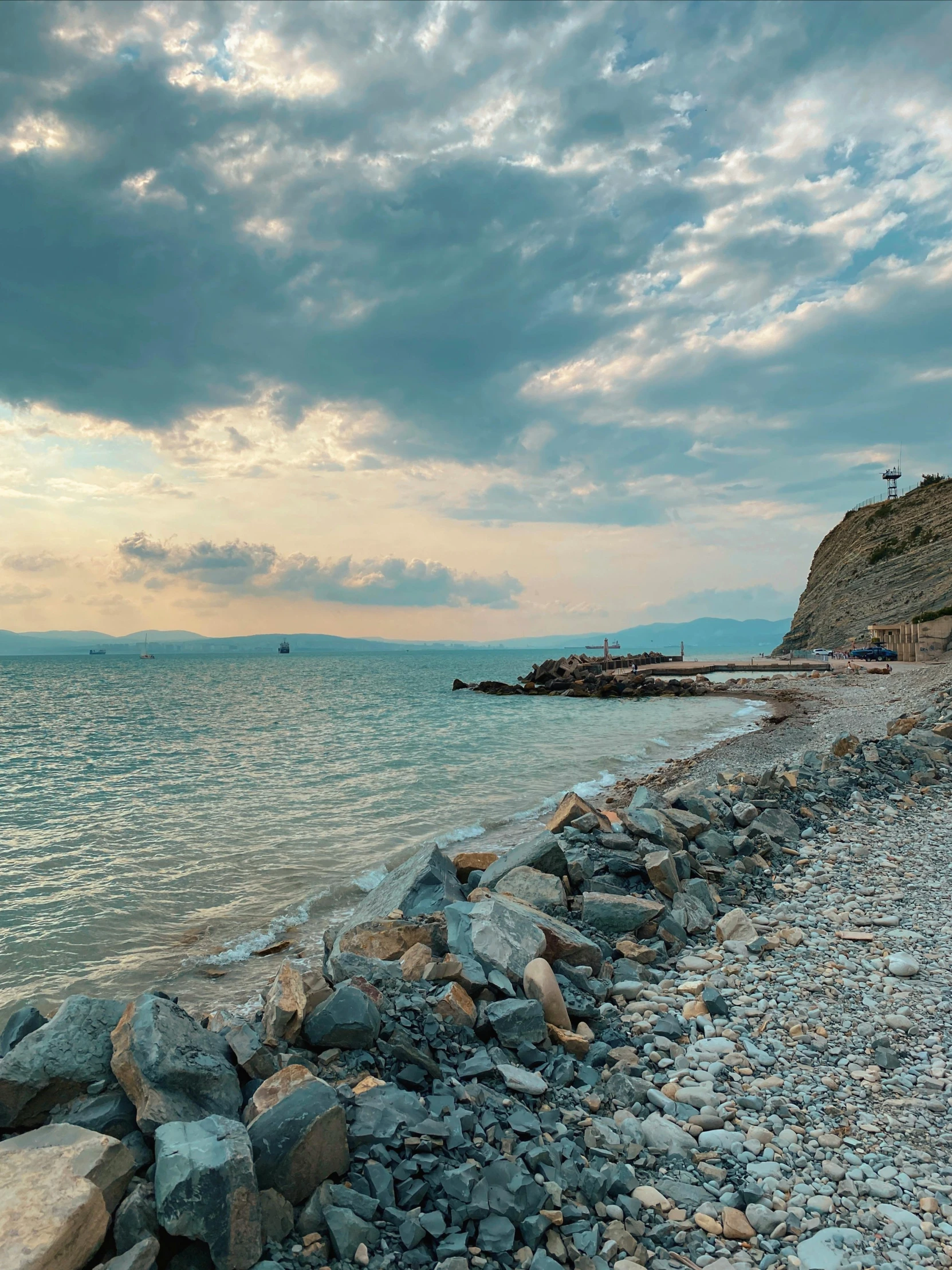 the rocks and gravel at the shore are by the water