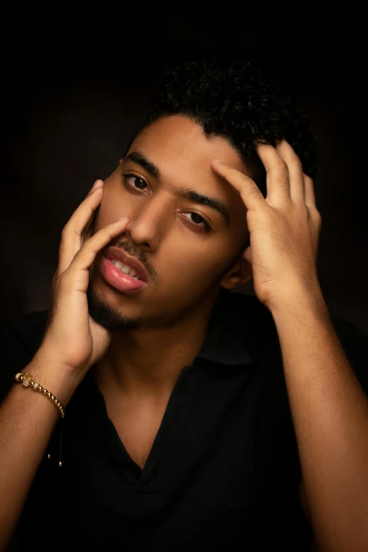 the young man is posing for a po with his hand on his ear