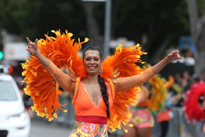 a woman in orange and yellow outfit at the parade