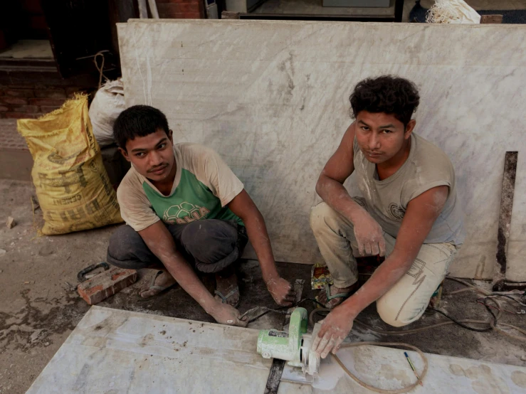 two young men working on fixing and fixing electrical wires