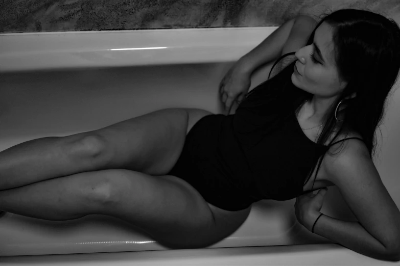 a woman in a tub in black and white