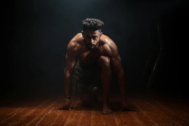 the man sits on a wooden floor and talks on his phone