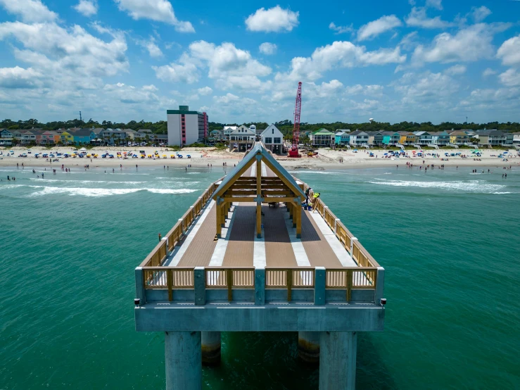 a dock on the edge of the water in front of beach