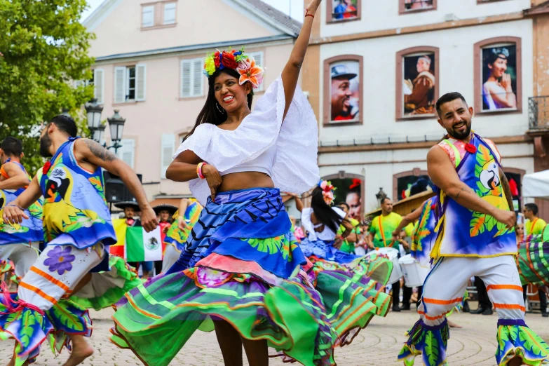 dancers are dressed in colorful clothing for a show