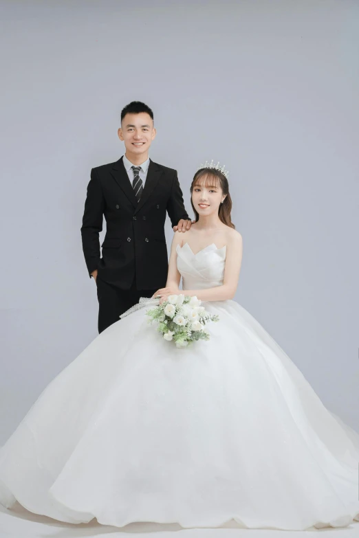 a young couple is wearing wedding dresses posing for a po