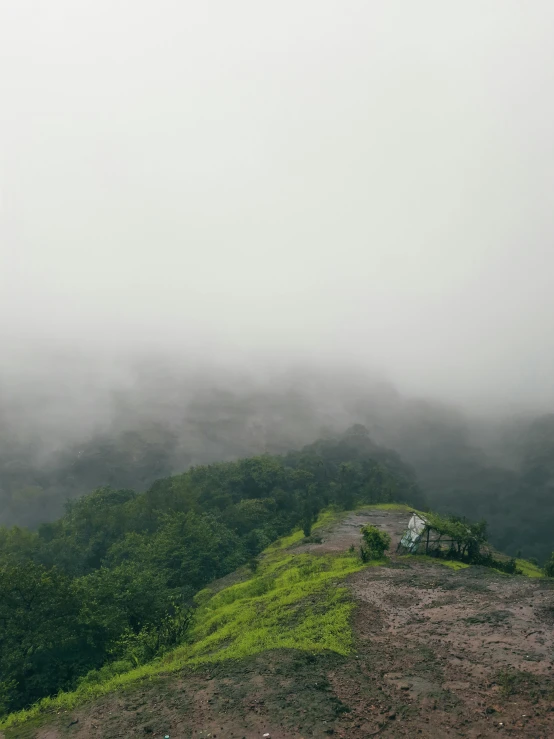 a scenic view of mountains in the fog and with a few people walking