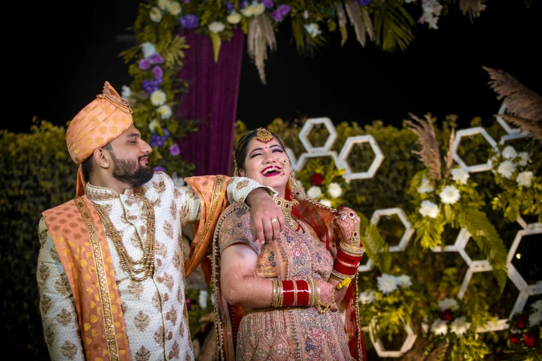 man and woman dressed in traditional indian garb are looking at soing