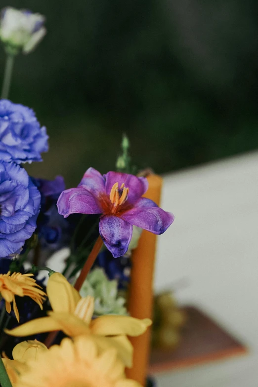 flowers and greenery are sitting in an orange vase