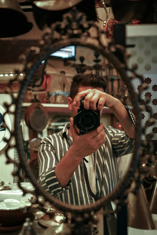 a man holding a camera up in front of a mirror