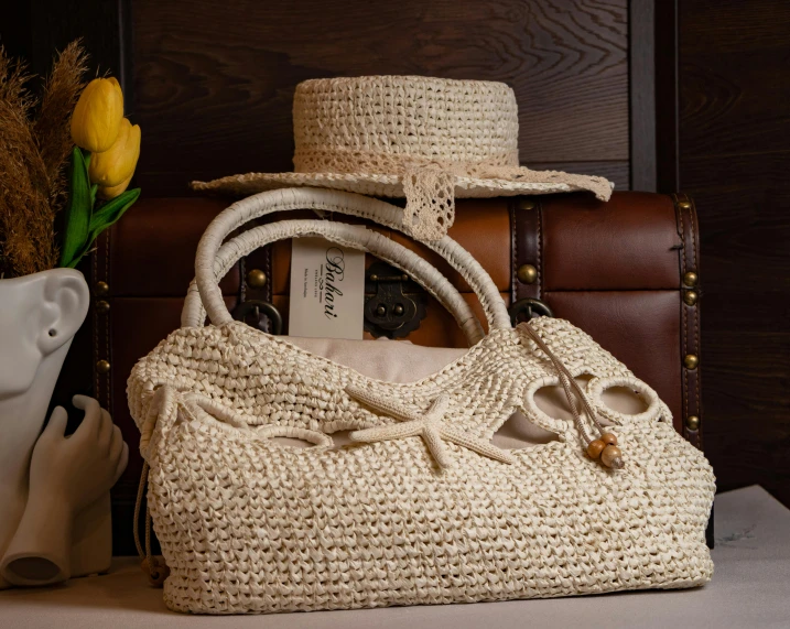 a white purse with a hat and some flowers