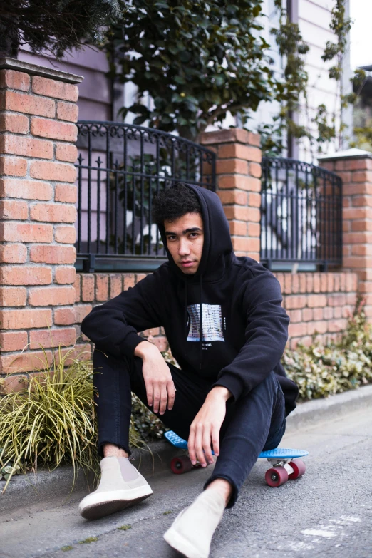 a man sitting on top of a blue skateboard