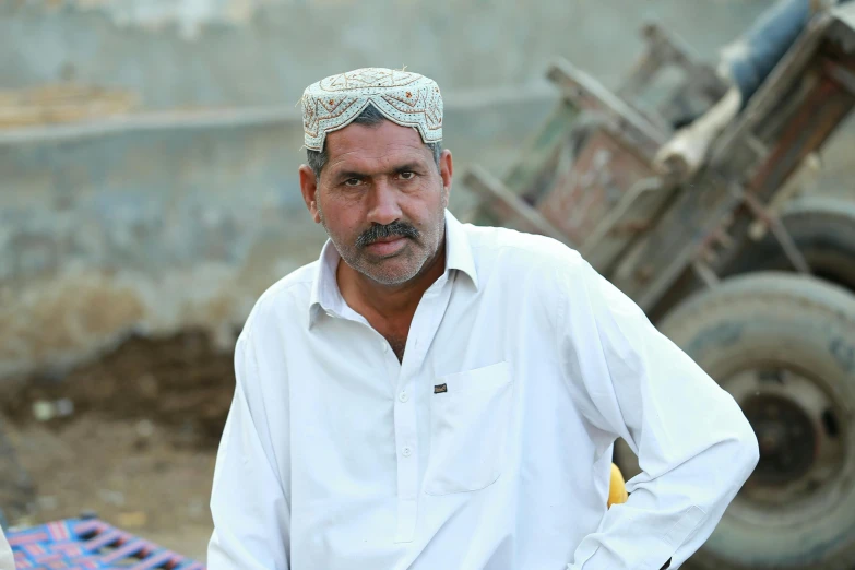 a man in white standing next to a construction site