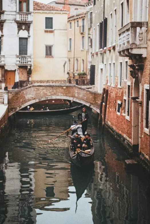 the boat is carrying a load of passengers down the canal