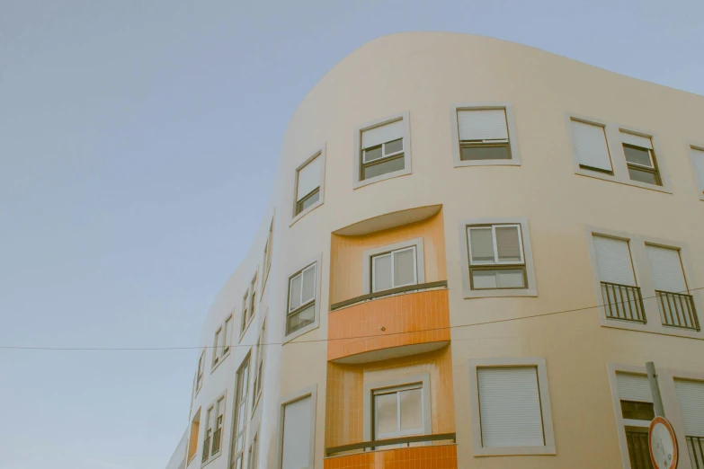 some people walking down the street and an orange building