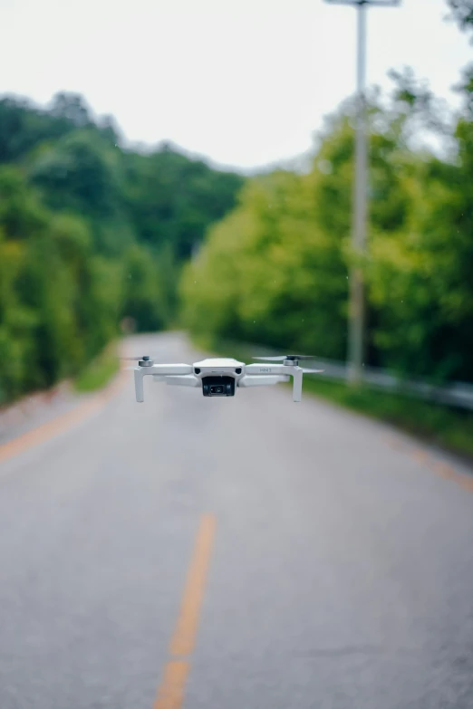 a small grey remote controlled flying device on the road