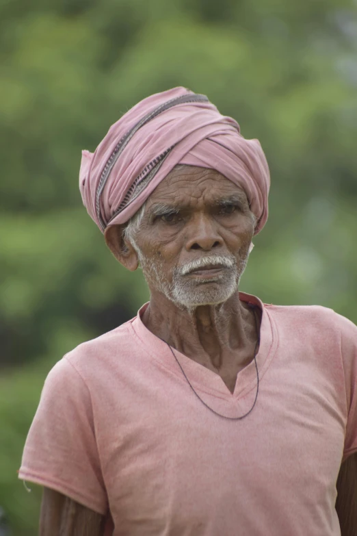 a man in pink shirt and turban standing