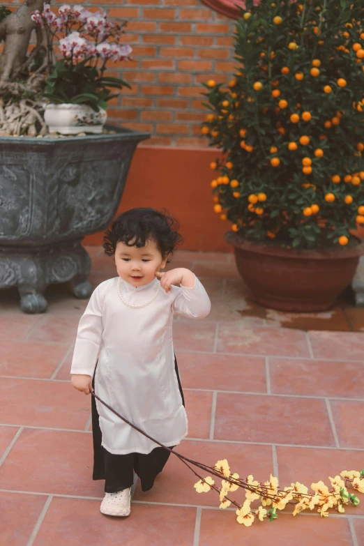 small child in white top walking on brick walkway