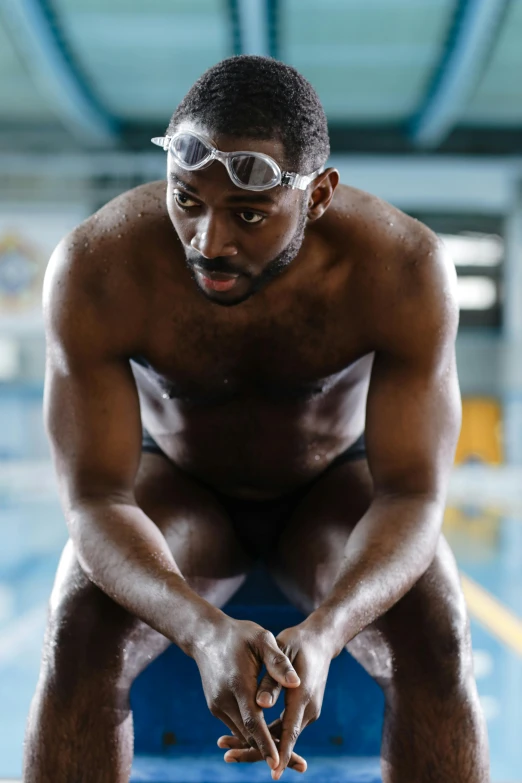 the young man is crouching down before doing a swim