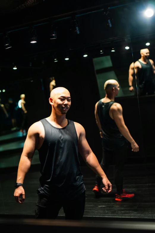 man looking at himself in the mirror at the gym