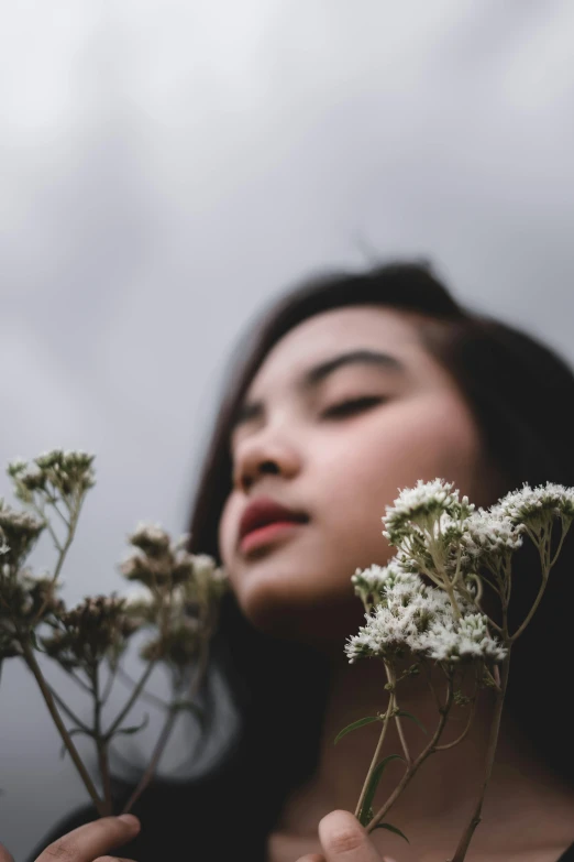 a woman holding a plant in her hands