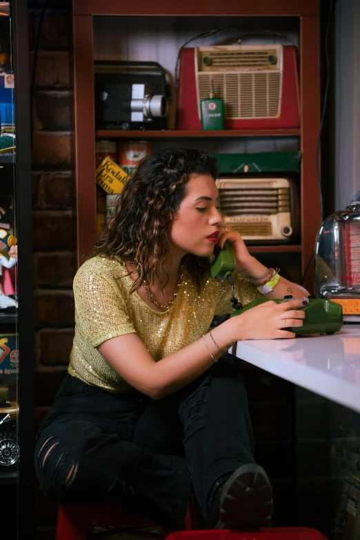 a woman sits at a white table holding a green object