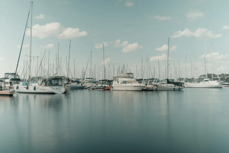 many boats are docked in the water near each other