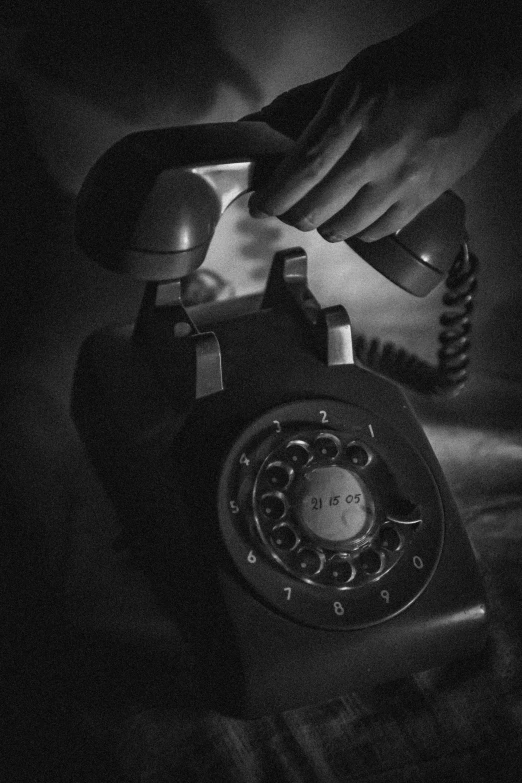 a person holding a rotary phone in their hand