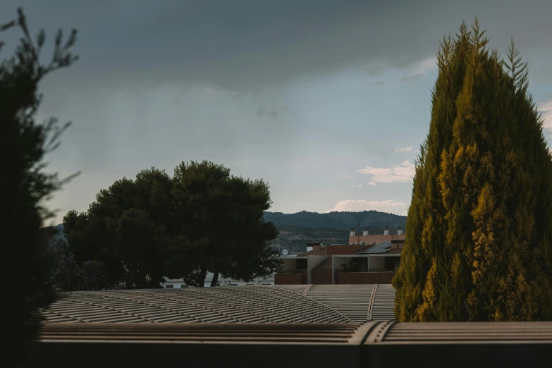 a building with some trees on a cloudy day